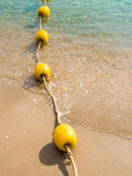 Плавучий буй і мотузка, що розділяє територію на пляжі
 - Фото, зображення