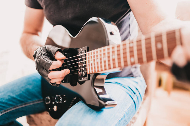 Close up of rocker guitarist hands playing heavy riff on electric guitar - Φωτογραφία, εικόνα