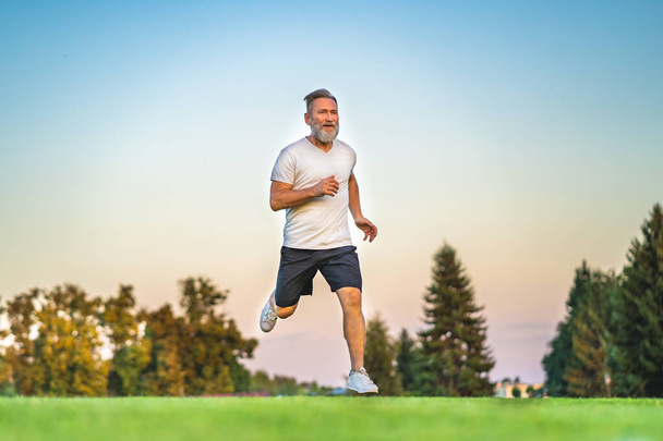 Stary sportowiec biegający po trawie - Zdjęcie, obraz