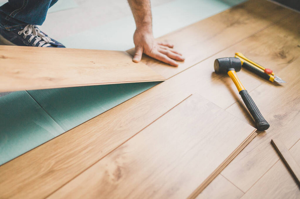 Professional flooring installation - laying a new laminate with a wooden pattern - Foto, imagen