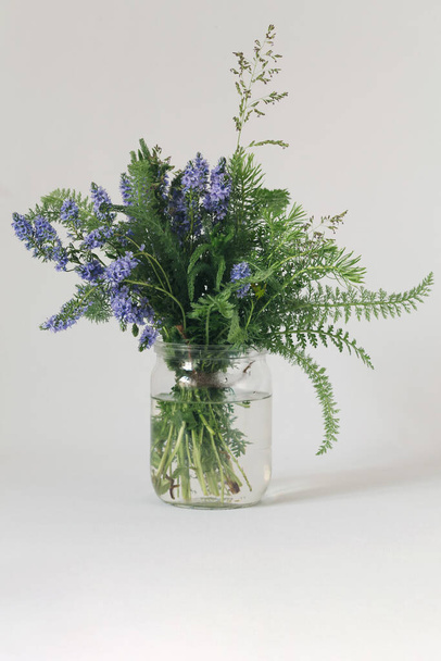 Rustic style transparent jar vase with veronica flowers bouquet. - Photo, Image