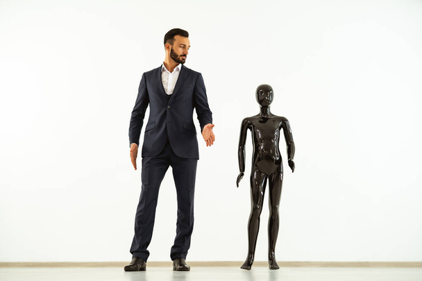 L'uomo in piedi con un manichino nero sullo sfondo bianco
 - Foto, immagini