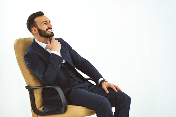 The happy businessman sitting on the office chair - Zdjęcie, obraz
