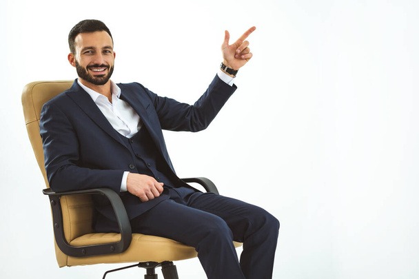 Szczęśliwy biznesmen siedzący na fotelu biurowym i gestykulujący - Zdjęcie, obraz