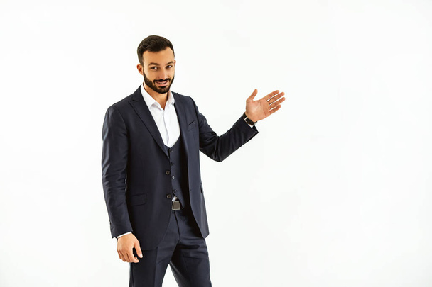 The businessman gesturing on the white wall background - Foto, immagini