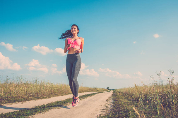 La deportista feliz corriendo en el camino de campo
 - Foto, Imagen