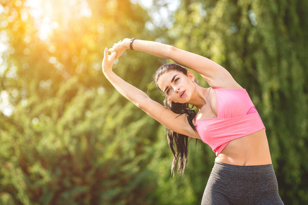 Счастливая спортсменка делает упражнения на солнечном фоне
 - Фото, изображение