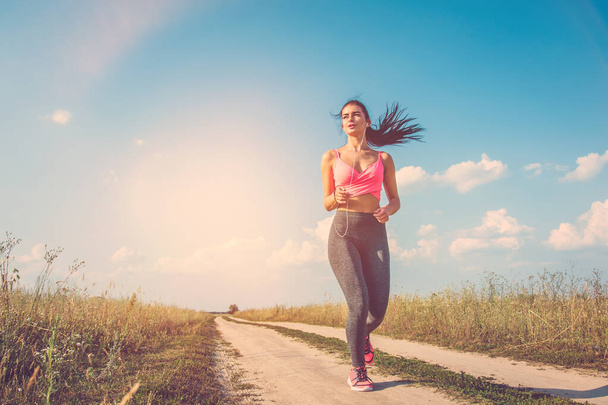 A nő fut a földúton a napfényes háttér - Fotó, kép
