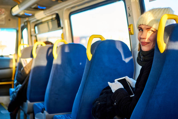 Woman with a phone in a bus. - Zdjęcie, obraz