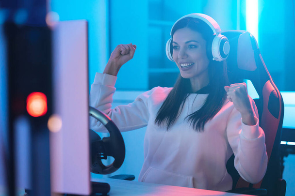 The beautiful gamer girl with headphones playing video games - Fotó, kép