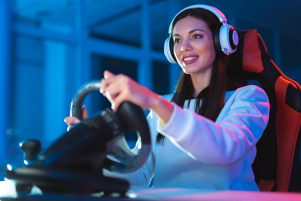 Девушка-геймер играет в видеоигры в темной комнате
 - Фото, изображение