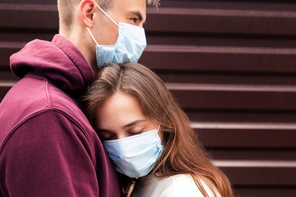 Young couple hugging wearing a face protection mask in the city since new coronavirus Covid 19 - Fotografie, Obrázek