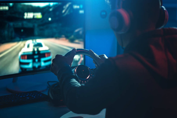 El tipo gamer con auriculares jugando videojuegos en el cuarto oscuro
 - Foto, Imagen
