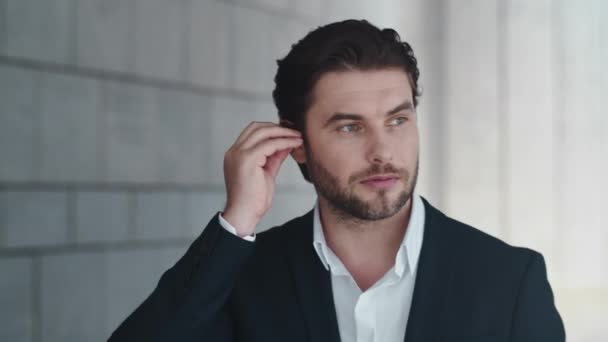 Businessman talking by wireless earphones in city. Employee using earbuds - Πλάνα, βίντεο