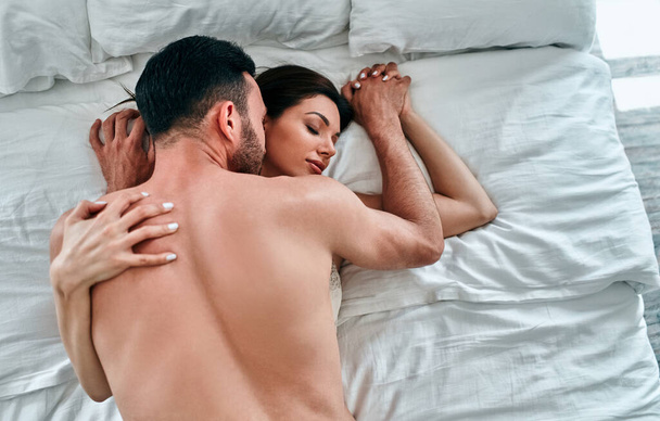 El hermoso hombre y la mujer en ropa interior teniendo sexo en la cama
 - Foto, imagen
