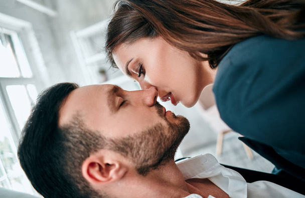 A mulher de negócios e homem beijando no quarto
 - Foto, Imagem