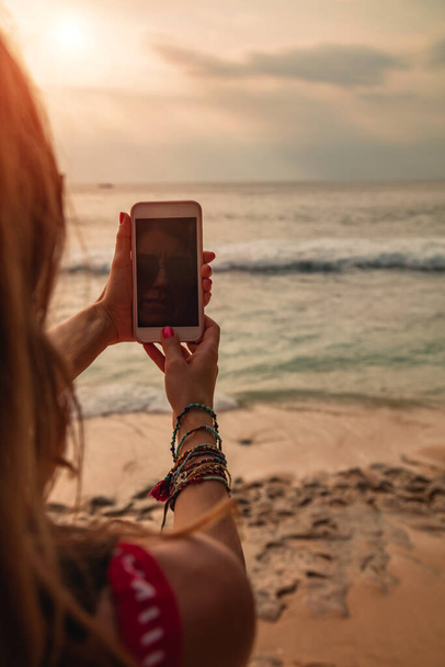 Woman tourist takign photos with her smartphone at a vacation on tropical island. - Foto, Imagen