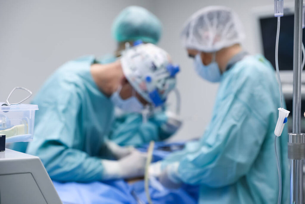 Blurred view of doctors operating patient in surgery room - Fotoğraf, Görsel
