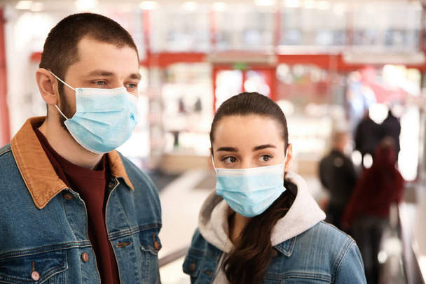 Couple wearing disposable masks in mall. Dangerous virus - Photo, image