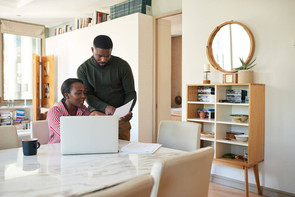 Young African American couple going over bills and doing some online banking at their dining room table at home - Fotoğraf, Görsel