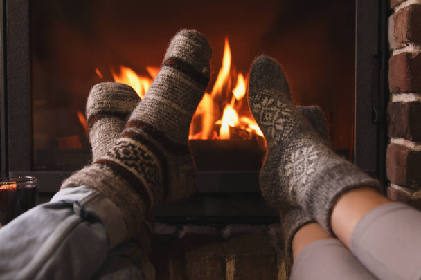 Couple resting near fireplace indoors, closeup. Winter vacation - Foto, Imagen