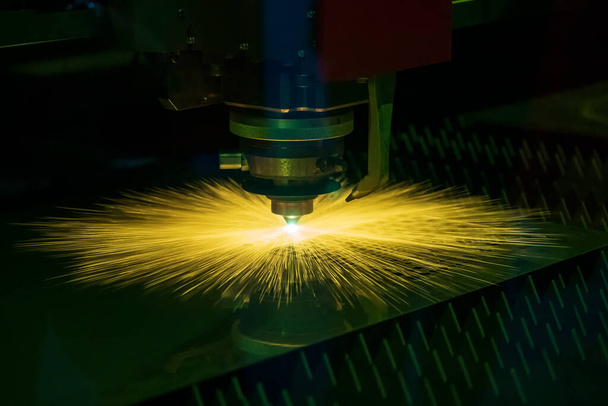 A szálas lézervágó gép elvágja a fémlemezt a csillogó fénnyel. A csúcstechnológiás fémlemez gyártási folyamat lézervágó géppel.  - Fotó, kép