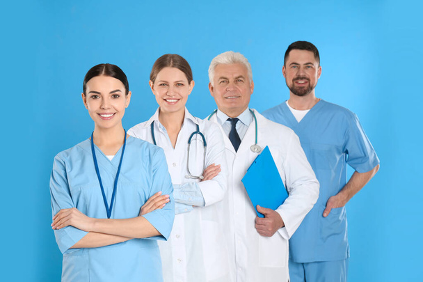Group of doctors against blue background. Medical service - Фото, изображение
