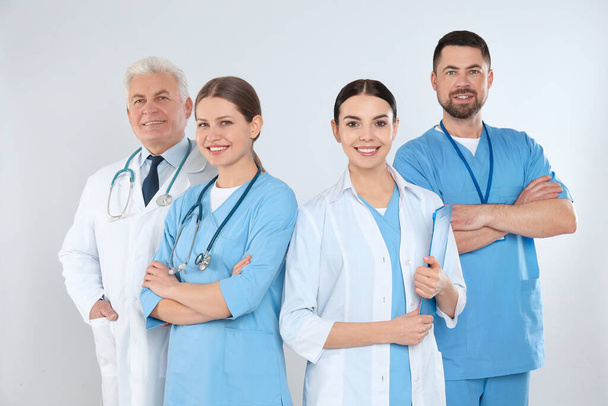 Group of doctors against light background. Medical service - Photo, Image