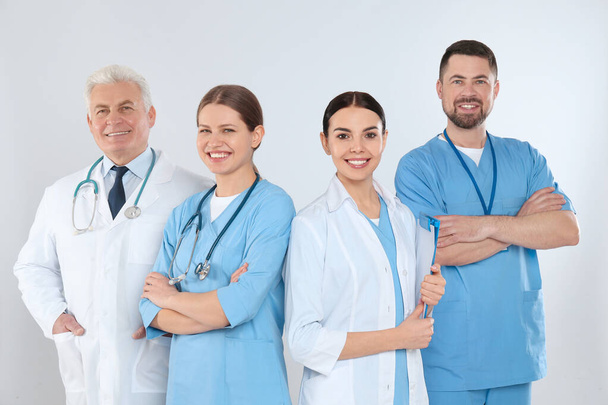 Group of doctors against light background. Medical service - Photo, image