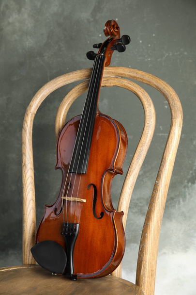 Classic violin on chair against grey background - 写真・画像