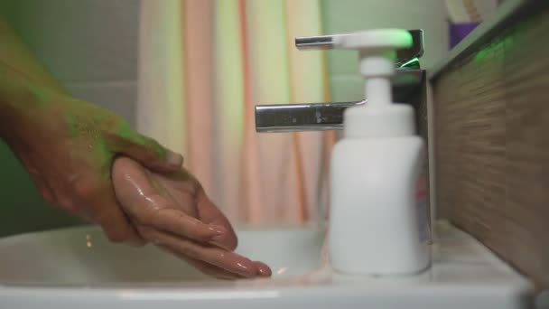 Handen wassen met kraanwater uit de gootsteen en schuim schoonmaken in de badkamer. - Video
