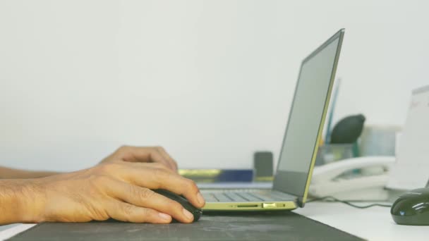 家で情報を検索し、オンラインで働くために無線マウスとノートパソコンを使用して男の手の閉じる,ウイルス19の流行の間に自宅から仕事のための概念. - 映像、動画