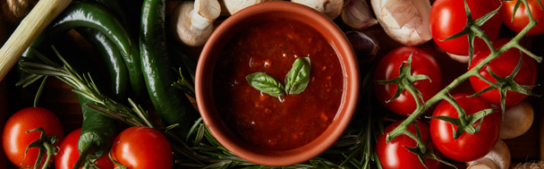 panoramic shot of tomato sauce with basil leaves near cherry tomatoes, green chili peppers, mushrooms and rosemary  - Photo, Image