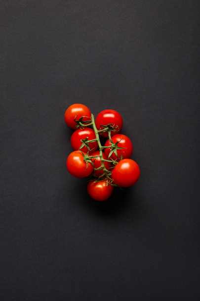 top view of organic and fresh cherry tomatoes on black - Valokuva, kuva