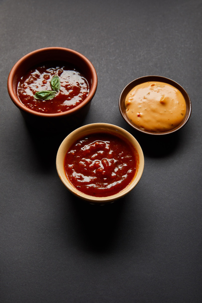 miski z czerwonym pomidorem i sosami musztardowymi na czarno - Zdjęcie, obraz