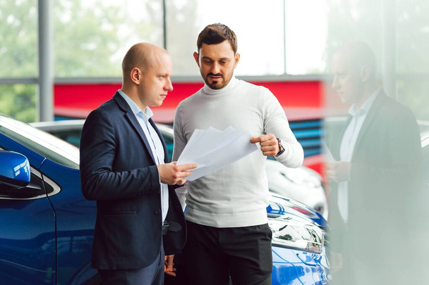 The seller and the buyer in the auto show - Foto, Bild
