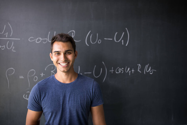 Students in a classroom - handsome student solving a math problem on a blackboard during math class - Photo, image