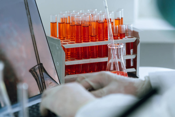 Doe dicht. wetenschapper werkt op een laptop in een modern laboratorium. - Foto, afbeelding