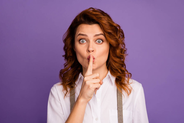 Closeup photo of pretty funny curly lady tricky mood hold finger on lips asking keep silence casino boss have confidential talk wear white shirt suspenders isolated purple color background - Photo, image