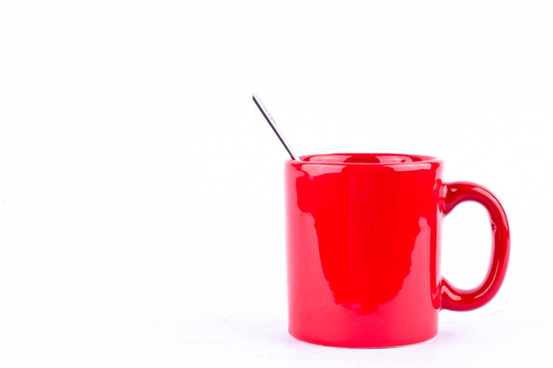 κόκκινο καφέ ή τσάι ή φλιτζάνι κούπα γάλα και κουτάλι σε λευκό ποτό φόντο απομονωμένο - Φωτογραφία, εικόνα