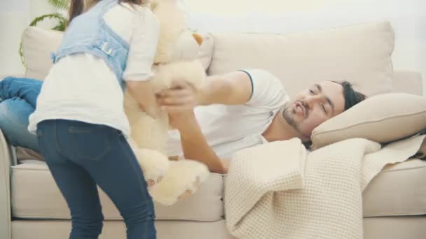 4k video where little girl using teddy bear to fight with her father. - Video