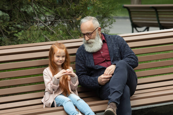Adorable little girl laughing happily while his bearded grandfather. Emotions expressive together family childhood parenting communication interacting lifestyle. - Fotoğraf, Görsel