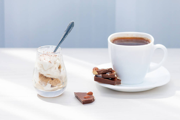 Cup of coffee, milk chocolate with nuts, ice cream with chocolate powder. Summer eat and drink for refreshment. - Photo, Image