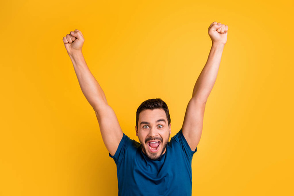 Close-up portrait of his he nice attractive glad overjoyed cheerful cheery guy celebrating raising hands up having fun isolated over bright vivid shine vibrant yellow color background - Foto, afbeelding