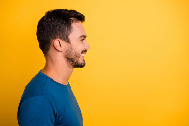 Close-up profile side view portrait of his he nice attractive cheerful cheery guy wearing blue tshirt copy space isolated over bright vivid shine vibrant yellow color background - Φωτογραφία, εικόνα