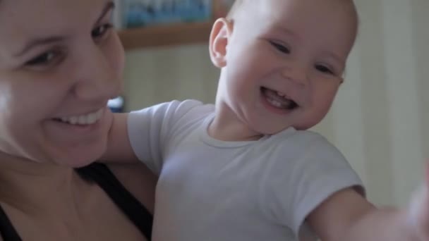 Mother Holds A Cheerful Playful Baby In Her Arms Who Tries To Talk - Filmati, video