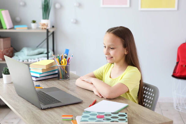 Un enfant apprend en ligne à la maison grâce à un ordinateur portable moderne sur Internet
. - Photo, image