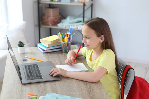 Ребенок учится дома через современный ноутбук в Интернете
. - Фото, изображение