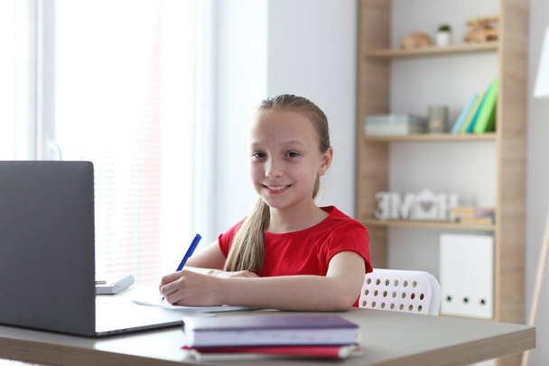 Un niño aprende en línea en casa a través de un portátil moderno en Internet
. - Foto, Imagen