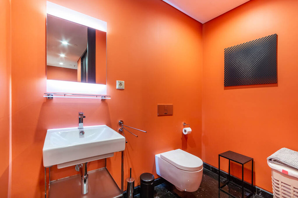 Restroom with toilet, washbasin and backlit illuminated mirror - Foto, Imagem